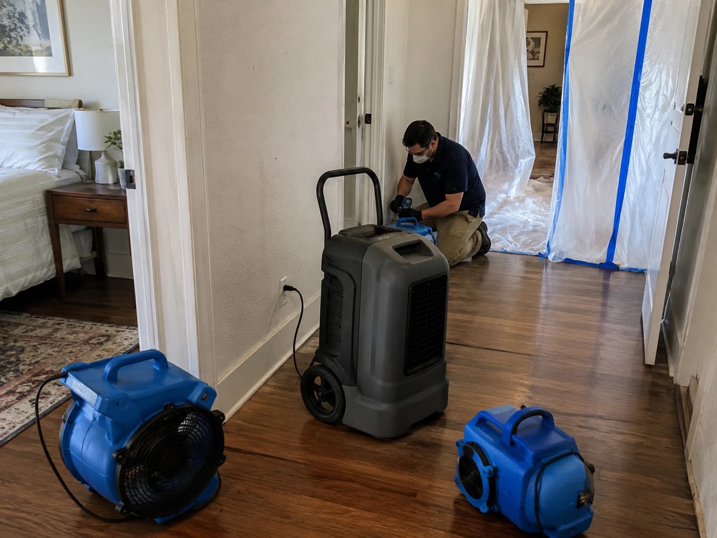 Technician evaluating concealed moisture in wall and cabinet zones